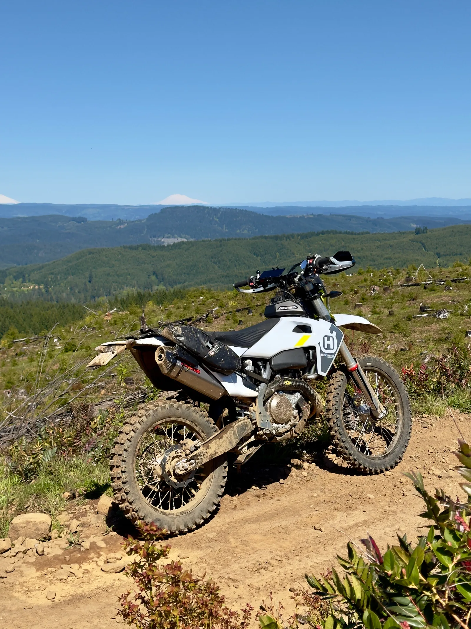 Orange KTM dirt bike framed against mountain ridges and a wide sky.